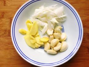 3，开始剥大蒜，喜欢大蒜味的可以多剥一些大蒜，再把大葱洗净切好，姜洗净去皮切片，香菜洗净去根切小段。