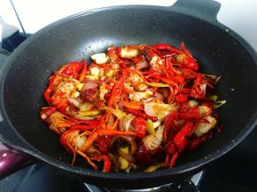 ​7，紧接着倒入过油备用的小龙虾进行翻炒。