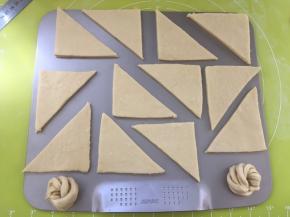 将裁好的小三角移到烤盘内，裁掉的边角可以扭成麻花，盖保鲜膜室温二次发酵，我的室温25度，发酵了一个小时，家里温度高的，建议放到凉快点的地方发酵