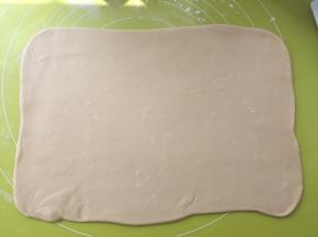 揉面垫上撒点干粉，将揉好的面团擀成长方形，大小是小号保鲜膜的大小