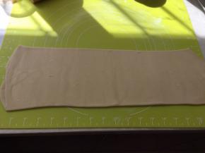 揉面垫上撒点干粉，将面片轻轻擀成长条，长度为揉面垫的长度