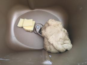 加入软化的黄油，继续启动揉面程序，将黄油跟面团揉均匀