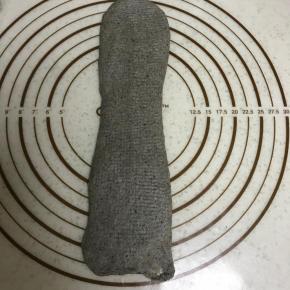 松弛好的面团进行第二次擀卷，由中间向两侧擀开，卷起