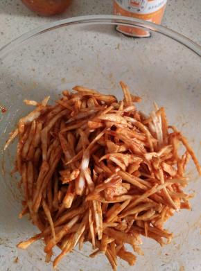 用手或者筷子混合均匀，使得每条杏鲍菇丝都均匀裹满酱料。