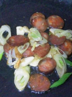 放入腊肠煸炒至辣肠呈透明后放入菜花煸炒