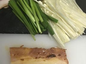 将培根切成两半，表面涂一层皇牌沙茶酱