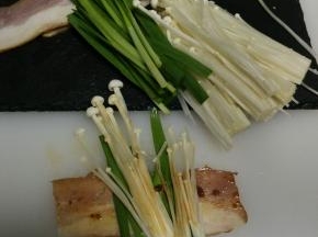 摆放上金针菇和韭菜，金针菇不要放太多，不易入味。表面再刷少许沙茶酱。卷起，用牙签固定住接口处。