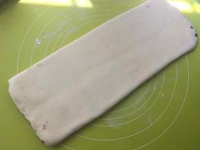 撒点干粉，将面片擀长，长度为揉面垫的长度