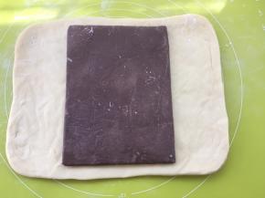 冰箱取出冷冻的面片跟豆沙片，用剪刀裁开豆沙保鲜袋，将豆沙片铺在面片中间