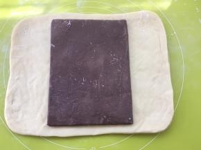 冰箱取出冷冻的面片跟豆沙片，用剪刀裁开豆沙保鲜袋，将豆沙片铺在面片中间