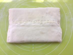 将两侧面片收起对折，包裹上豆沙馅，捏紧收口