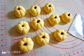 然后用刮面板印出南瓜表面的纹路，顶部轻轻按一下，塞进葡萄干。