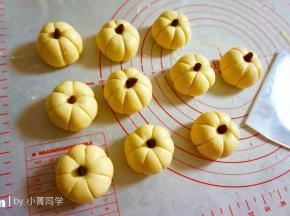 然后用刮面板印出南瓜表面的纹路，顶部轻轻按一下，塞进葡萄干。