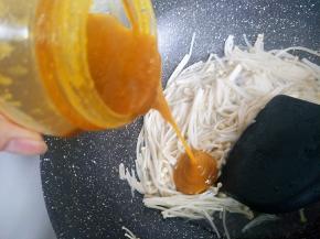 再倒入适量的酸汤酱翻炒到差不多断生