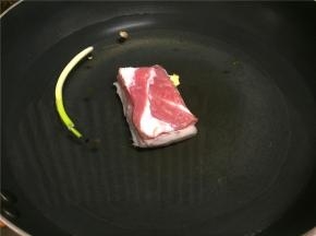 将五花肉放入锅中，加入适量花椒、生姜、葱头煮过心（煮熟）。