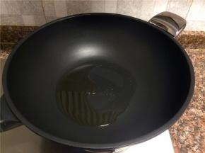 热锅倒油烧至七成热。