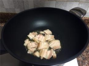 放入五花肉煸炒至肉微卷，表面微微发黄。