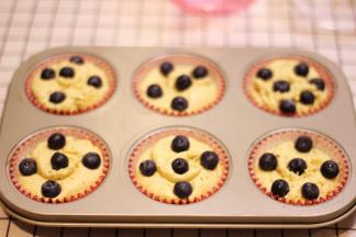 把面糊装裱花袋，先在纸杯蛋糕底部挤一层，放入几颗蓝莓，再挤一层面糊，放上几颗蓝莓