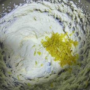 黄油高速打发至颜色发白后放入柠檬皮碎，打匀