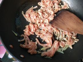 锅内放油，烧热，将一部分生姜爆香后放入肉丝。