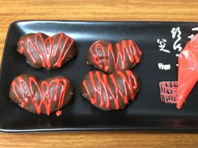 等草莓上的巧克力凝固后，再挤入加入色素的巧克力，随意画