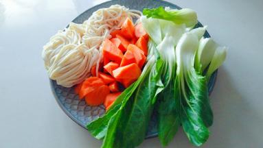 准备湿面，胡萝卜切块上海青清洗干净。