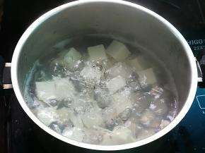 锅中加水约1000ml，放入姜丝烧开后加入豆腐和白贝，煮至白贝开壳
