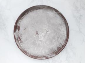 披萨盘撒上干面粉再抖掉多余的面粉。