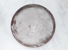 披萨盘撒上干面粉再抖掉多余的面粉。
