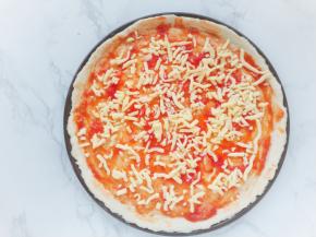 用油刷蘸取浓稠的酱汁，刷在饼皮上，撒上马苏里拉芝士碎。