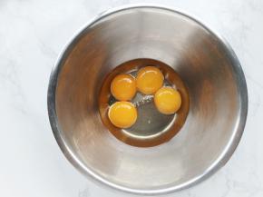 蛋白蛋黄分放在两个无水无油的盆中。蛋黄中加入玉米油，搅打均匀。