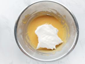 将三分之一的蛋白霜加入蛋黄糊中，用手动打蛋器拌匀。