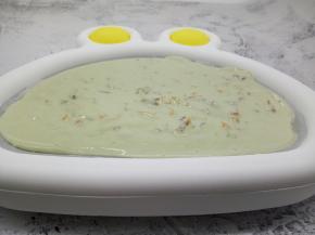 两手端在炒冰机的两端，轻轻左右晃动炒冰机，让酸奶均匀地发布在炒冰机上