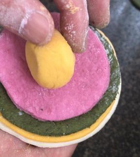 把四色面皮重叠在一起，在把小丸子放中间