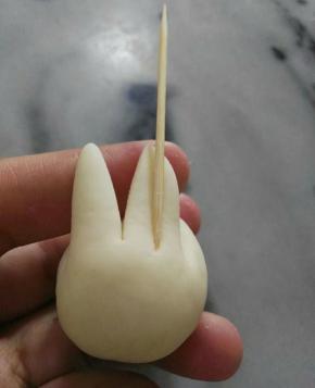 剪好，再平均剪开，成耳朵。再用牙签压一下两边的耳朵。