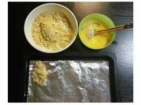 将鸡翅裏满蛋液，再放入薯片碎里打滚粘满薯片碎。