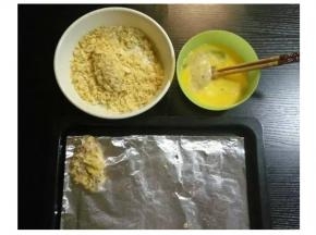 将鸡翅裏满蛋液，再放入薯片碎里打滚粘满薯片碎。