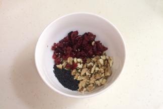 准备好黑芝麻，把核桃仁掰碎，把蔓越莓稍微切下备用。