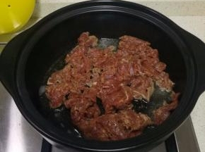 锅子洗净，开大火烘干水分。往砂锅里倒入适当的食用油。油不是很热的时候倒入牛肉。