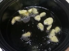 砂锅洗净，开大火烧干水分，倒入适量食用油，茄子是需要油多才能好吃的菜，稍微比平时做菜多放些油。放入切碎的大蒜，爆香。