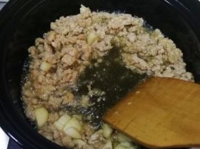 加入腌过的猪肉馅，小火炒至变色，放入一勺豆瓣酱，炒香，炒出红油。