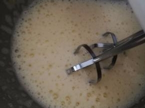 打蛋盆坐在热水里，用电动打蛋器开始打鸡蛋。