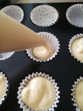 裱花袋剪个口子，将面糊挤入小纸托中，八分满。