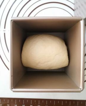 卷好的面团放入吐司盒中，放温暖湿润的地方发酵到九分满，盖上吐司盖。