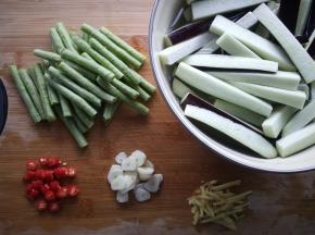 豆角用手摘断，茄子切长条，放入淡盐水中浸泡十分钟，蒜切片，姜切丝，小米椒切小段。