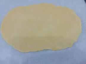 饧好的面团取出，底部和上面盖上油纸然后擀成和紫薯泥长长方形