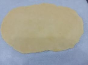 饧好的面团取出，底部和上面盖上油纸然后擀成和紫薯泥长长方形