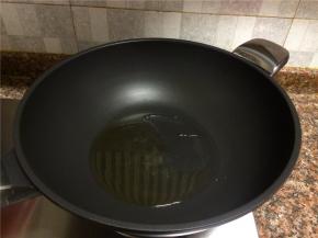 热锅倒油烧至八成热。
