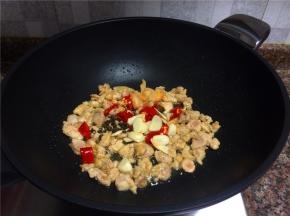 放入花椒、大蒜、泡椒和泡姜翻炒10秒。