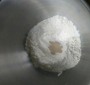 除黄油以外的所有材料按照下层液体上层粉类放入厨师机启动揉面程序。揉到面团光滑加入软化的黄油，揉到能拉出大片的膜